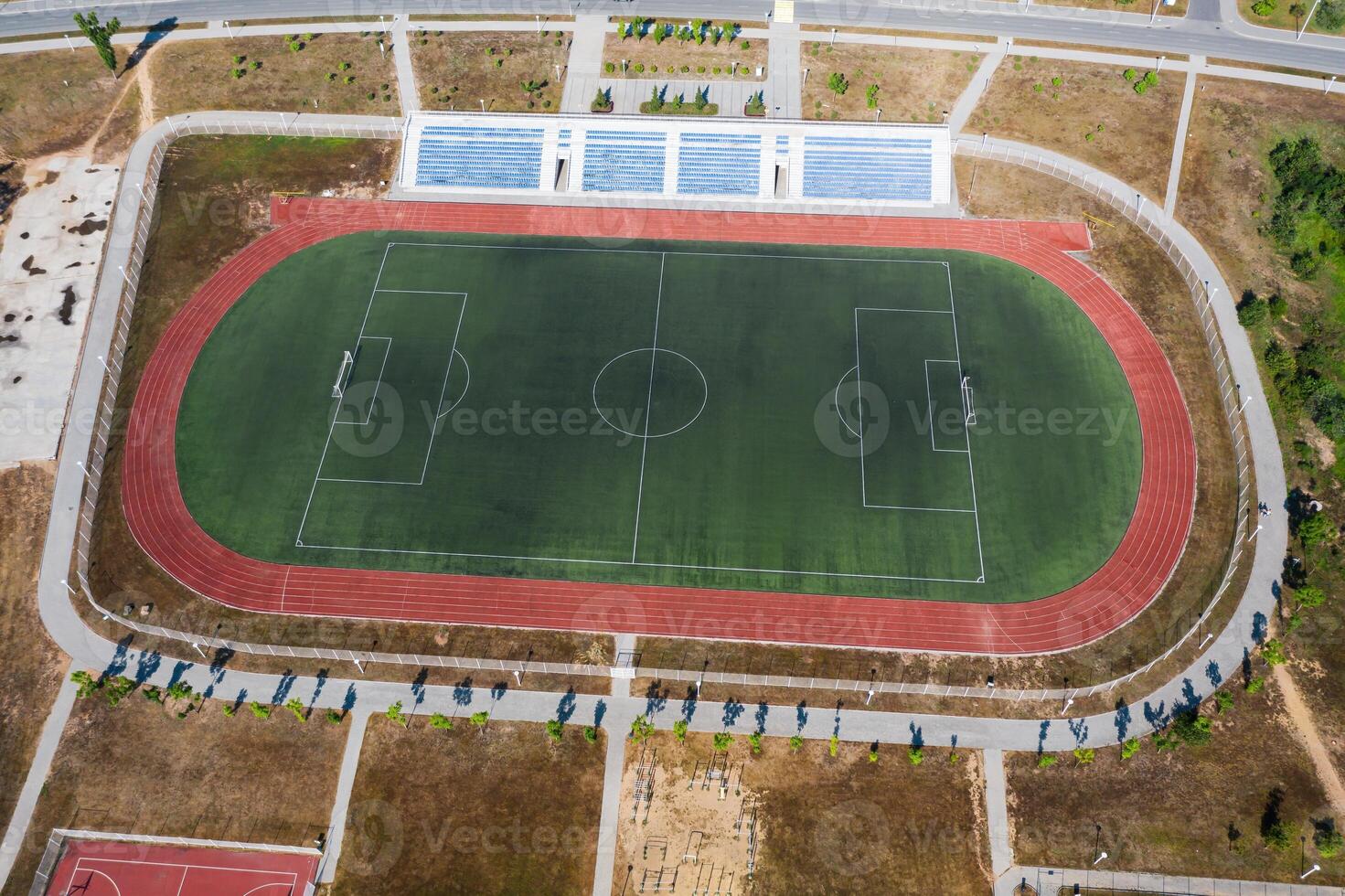 Drone view of an empty soccer field with stands and treadmills photo