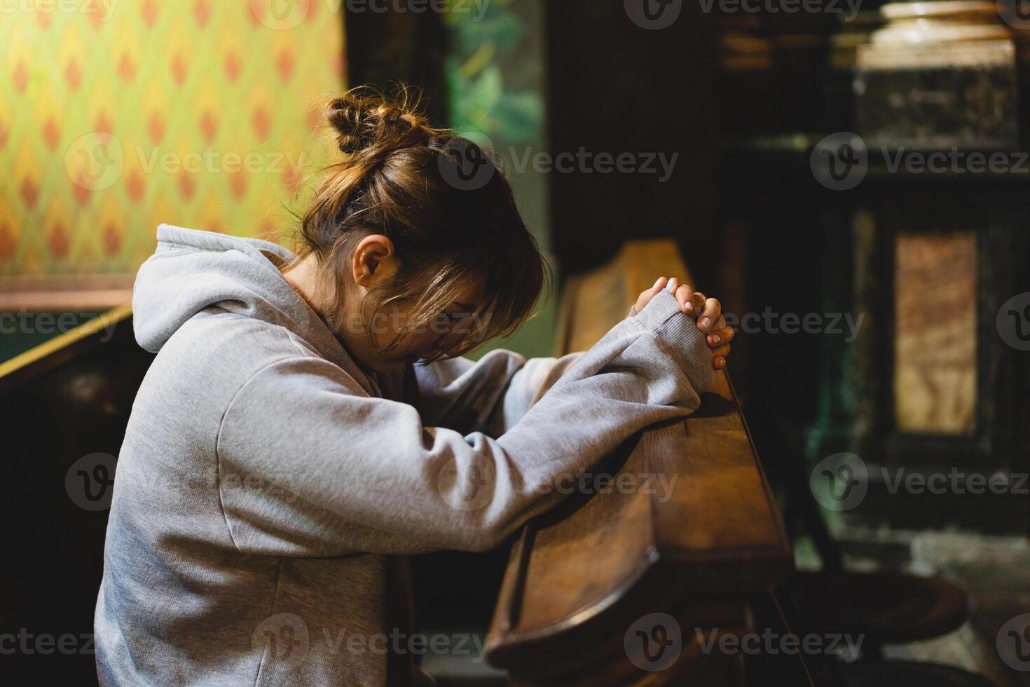 Woman praying on her knees in an ancient Catholic temple to God. photo