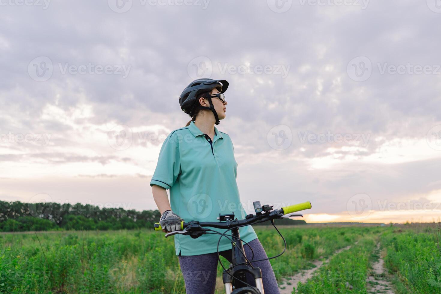 Woman Riding a Mountain Bike on a Dirt Path Near Suburbia photo