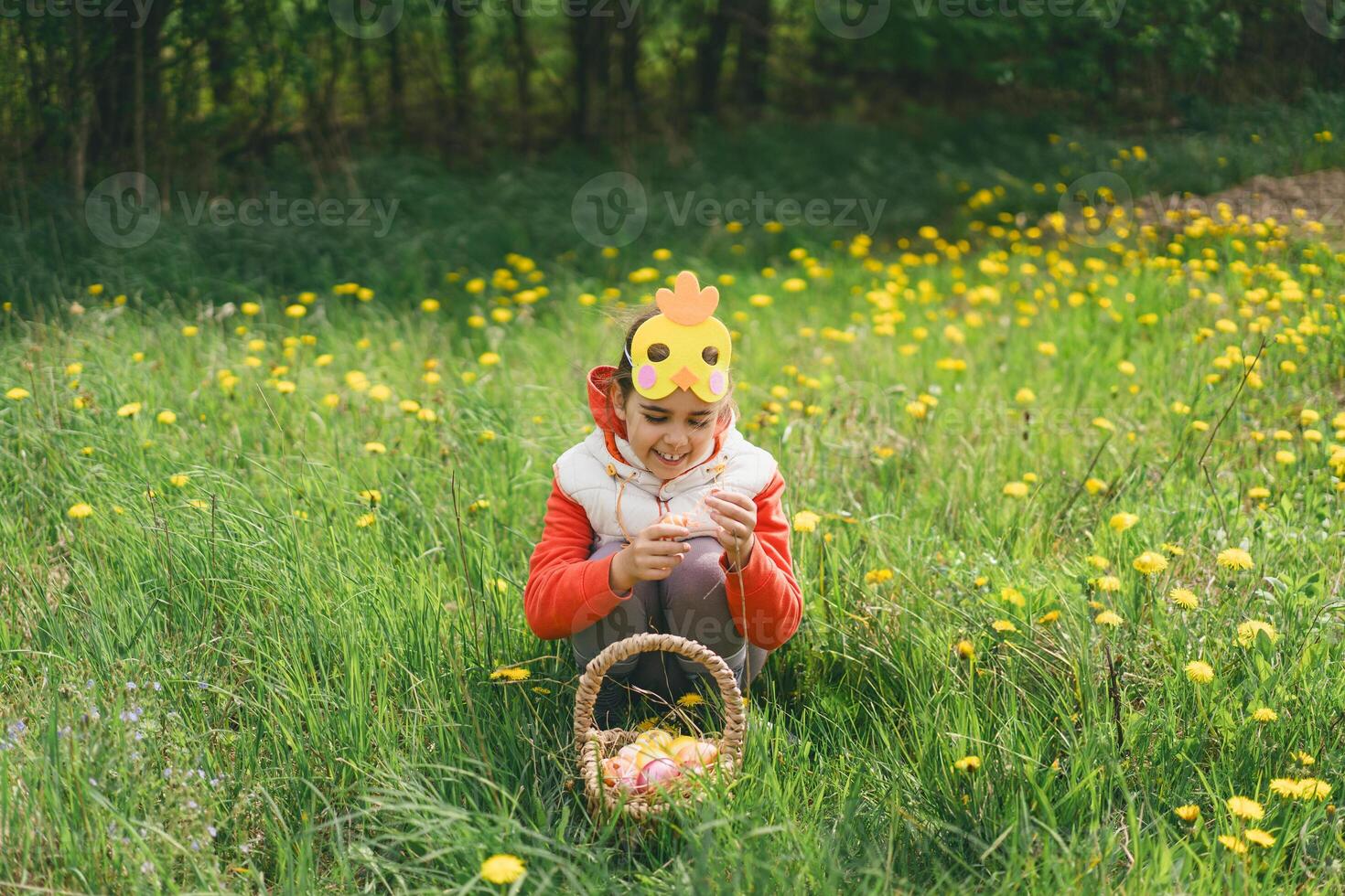 Girl with eggs basket and with a chicken mask on Easter egg hunt photo