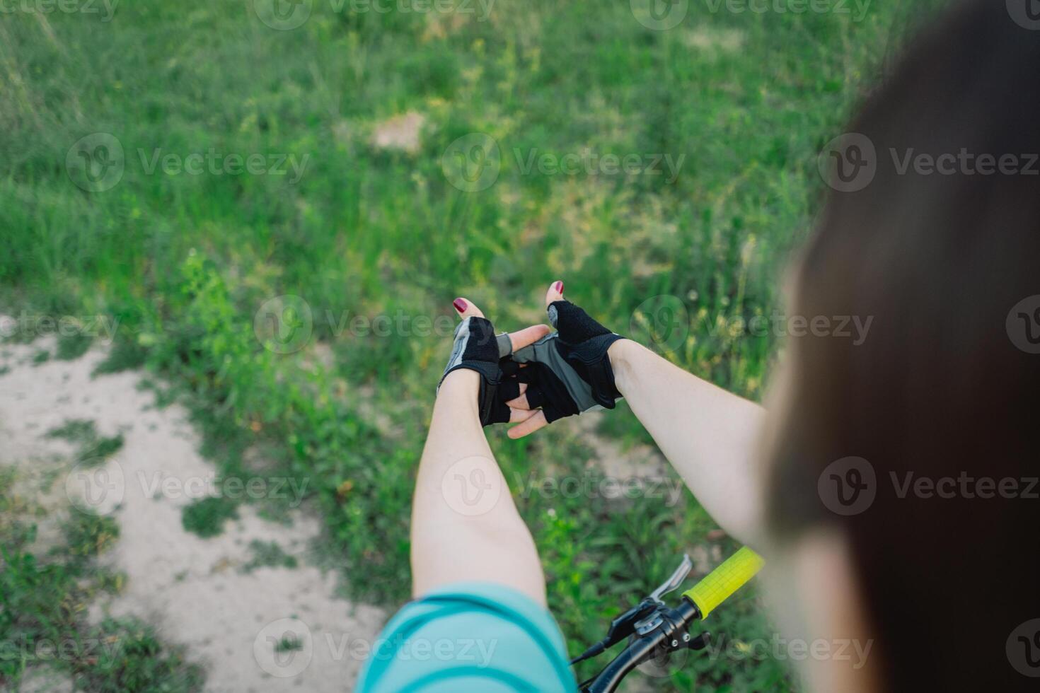 Woman Wearing Black Gloves Rides Mountain Bike on Trail photo