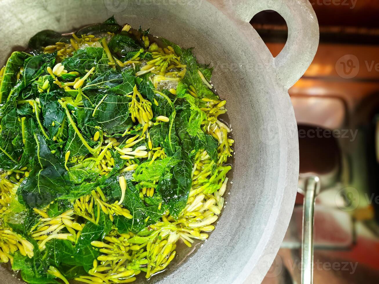 papaya shoots and leaves boiled in a cauldron photo