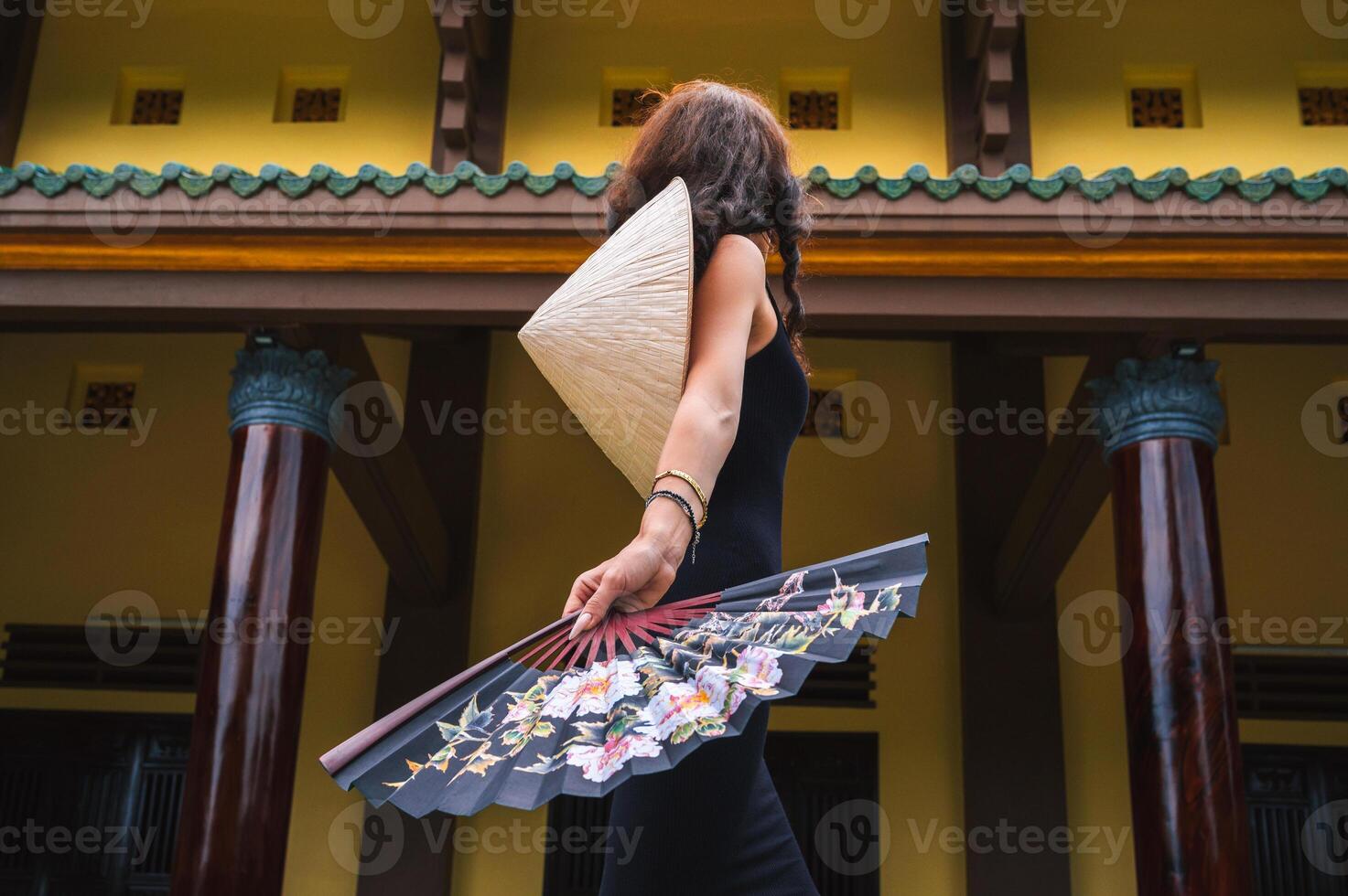 A tourist woman in a traditional Vietnamese Non La hat on the background of beautiful landscapes at the Linh Ung Son Tra pagoda in Da Nang. photo