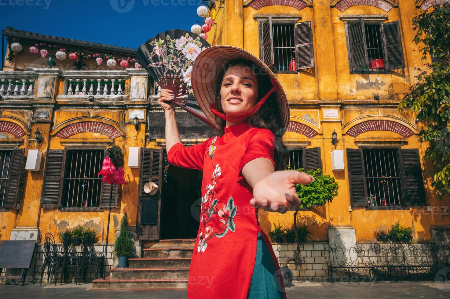 Portrait of a young woman in a traditional costume of Vietnamese culture in the ancient Hoi An area, Vietnam photo