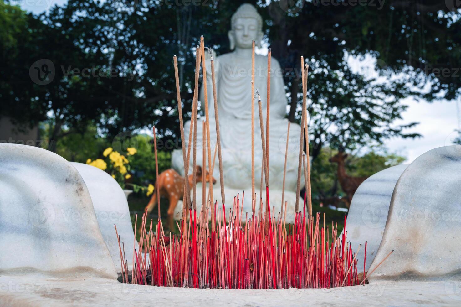 a bowl of incense on the background of a white Buddha in foliage at the Da Nang pagoda Linh ung photo