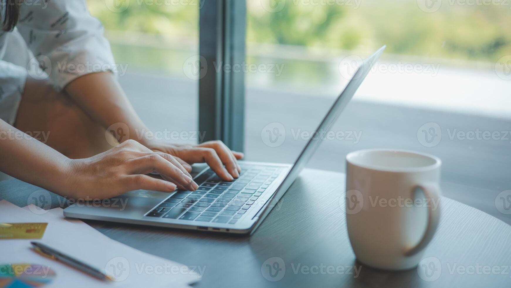 Businesswoman typing on laptop computer keyboard on wood desk at office, Technology, Business concept. Business woman analyze the graph of the company performance to create profits and growth. photo
