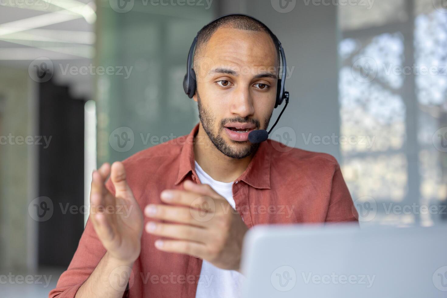 Man with headset and laptop talking using call, support service worker at workplace inside office. Advises customers consumers. Business meeting remote conference. photo