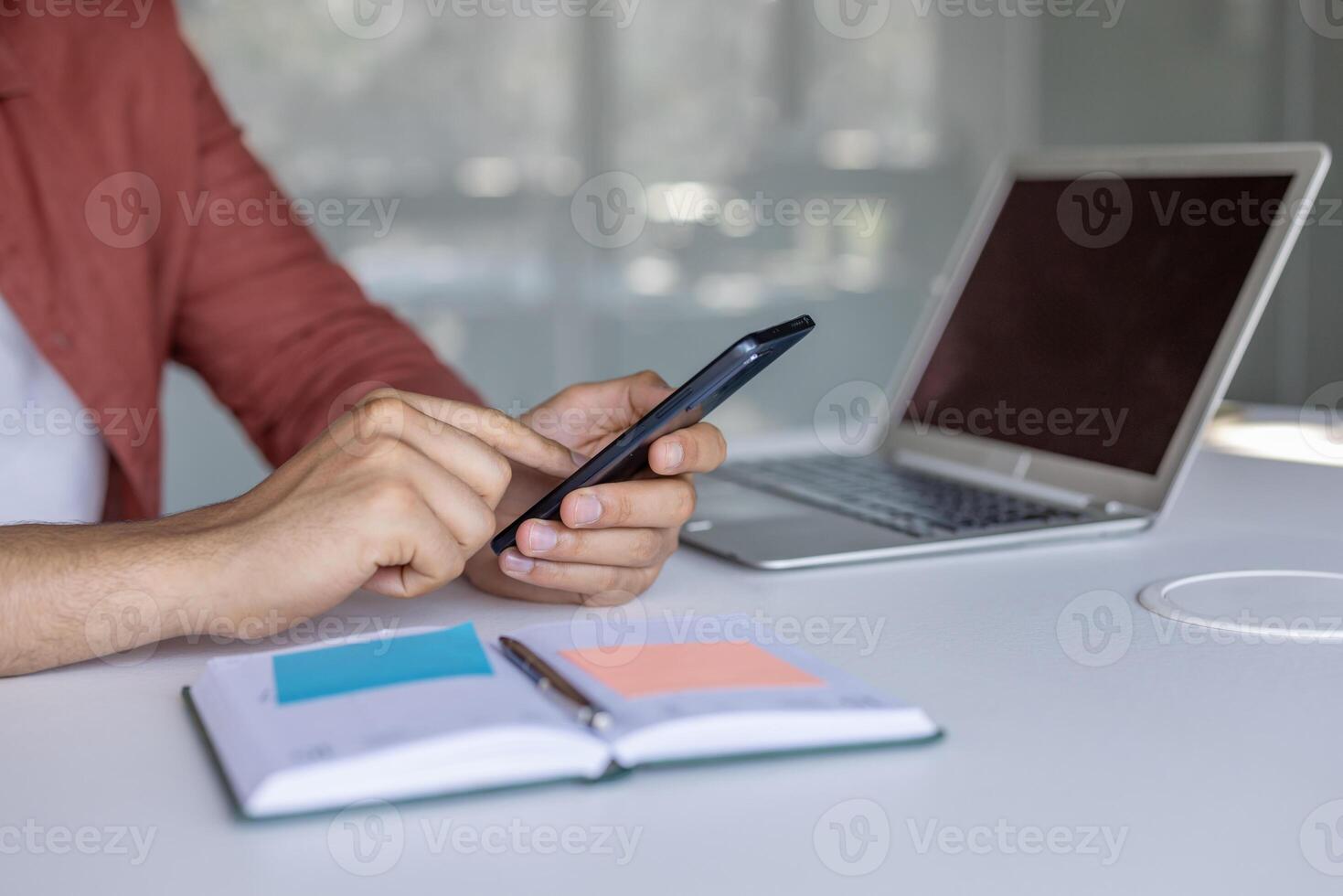Man hands using phone inside office at workplace, man typing message on using online app to view investment reports. photo