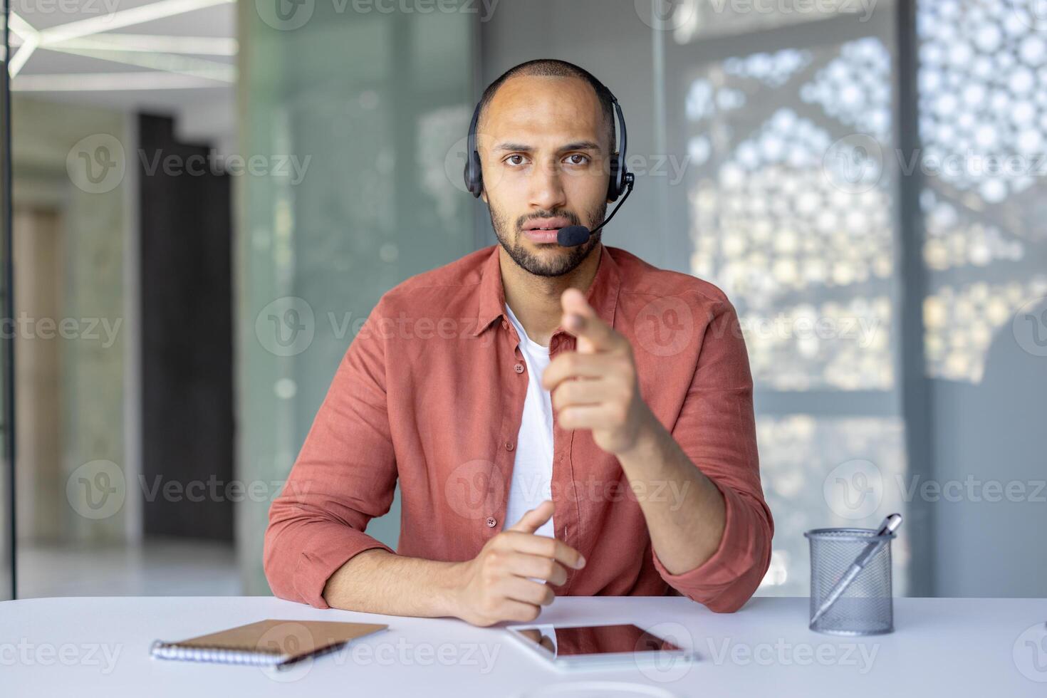 Person wearing a headset communicating via call while working in a contemporary workspace. Related to remote work, communication, and modern technology. photo
