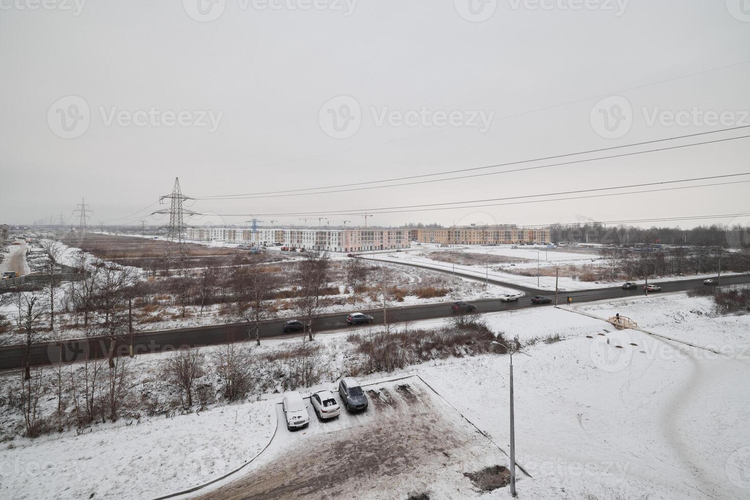 A snowy landscape featuring an overcast sky alongside various infrastructure elements photo