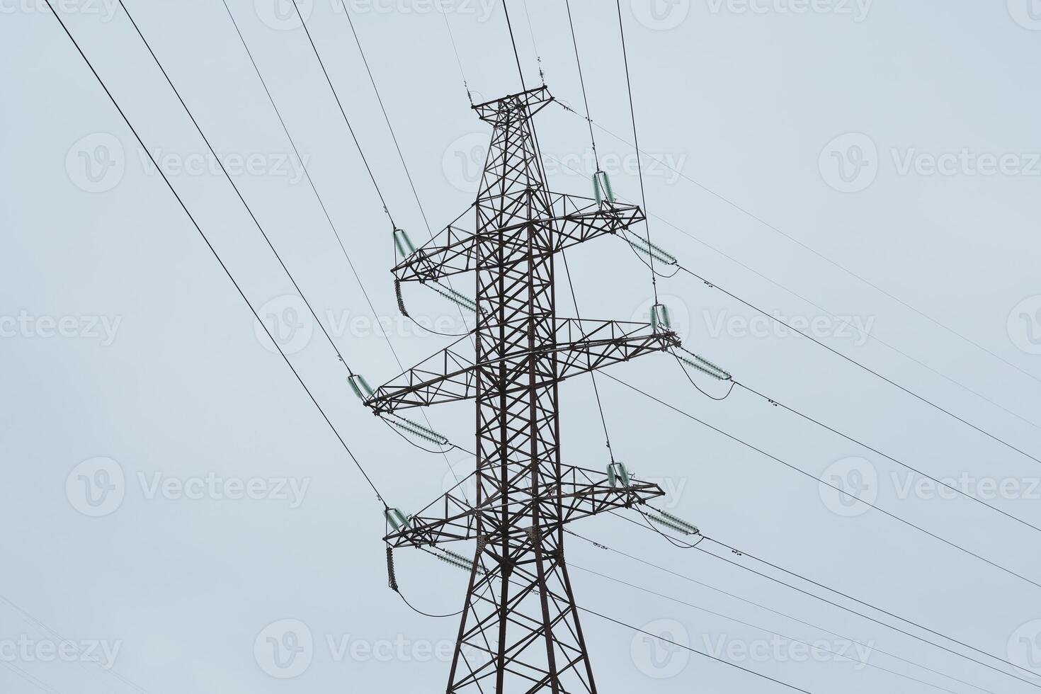 The towering high voltage power lines stand prominent against the expansive sky overhead photo