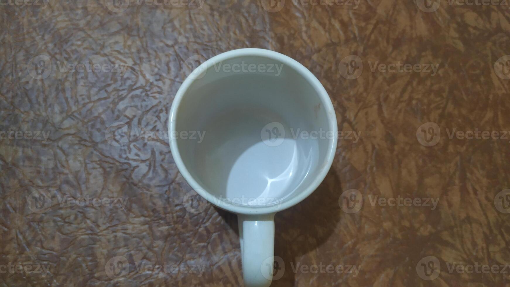 a white coffee cup sitting on top of a wooden surface photo