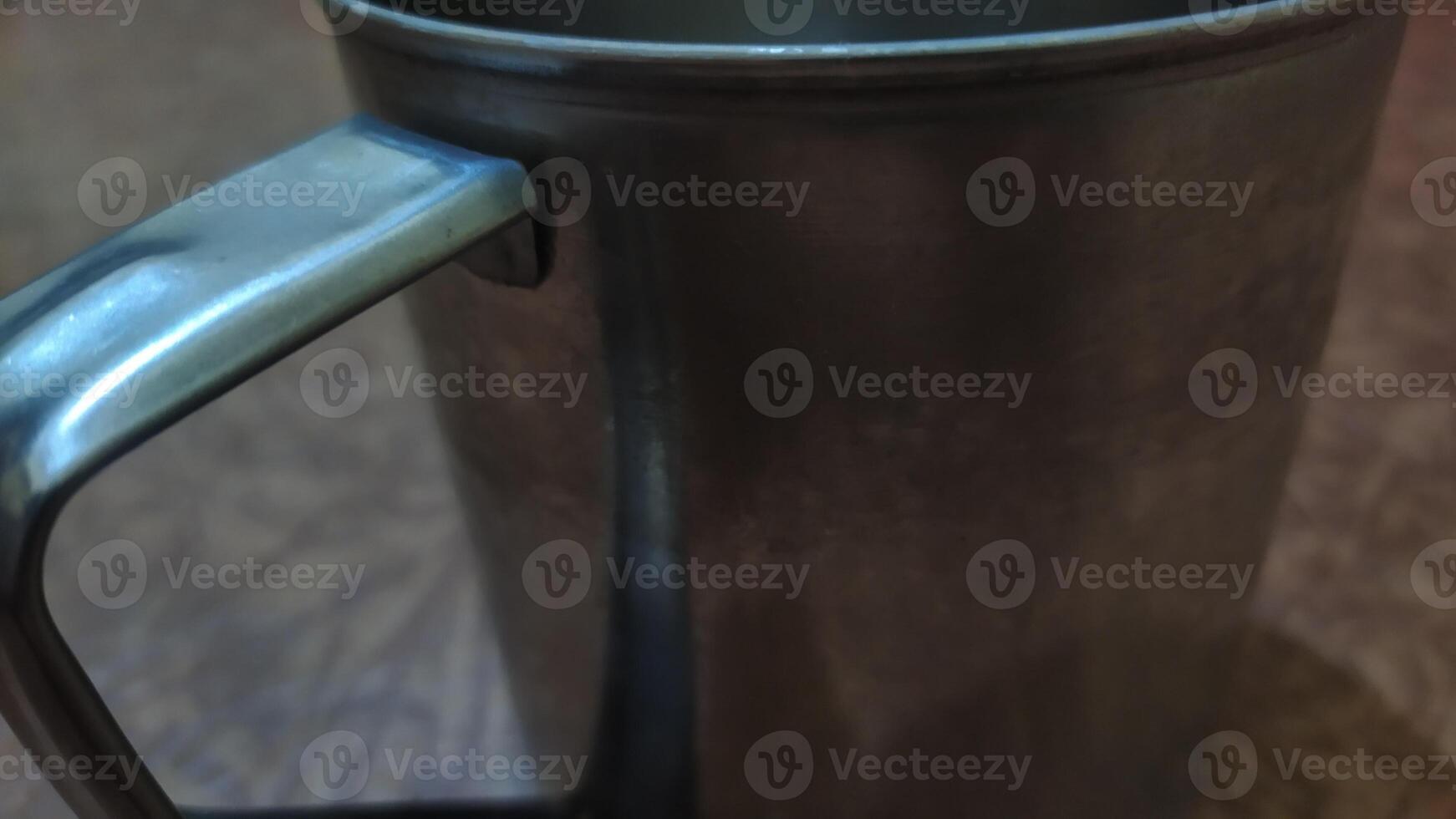 a metal mug with a handle on a table, close-up photo