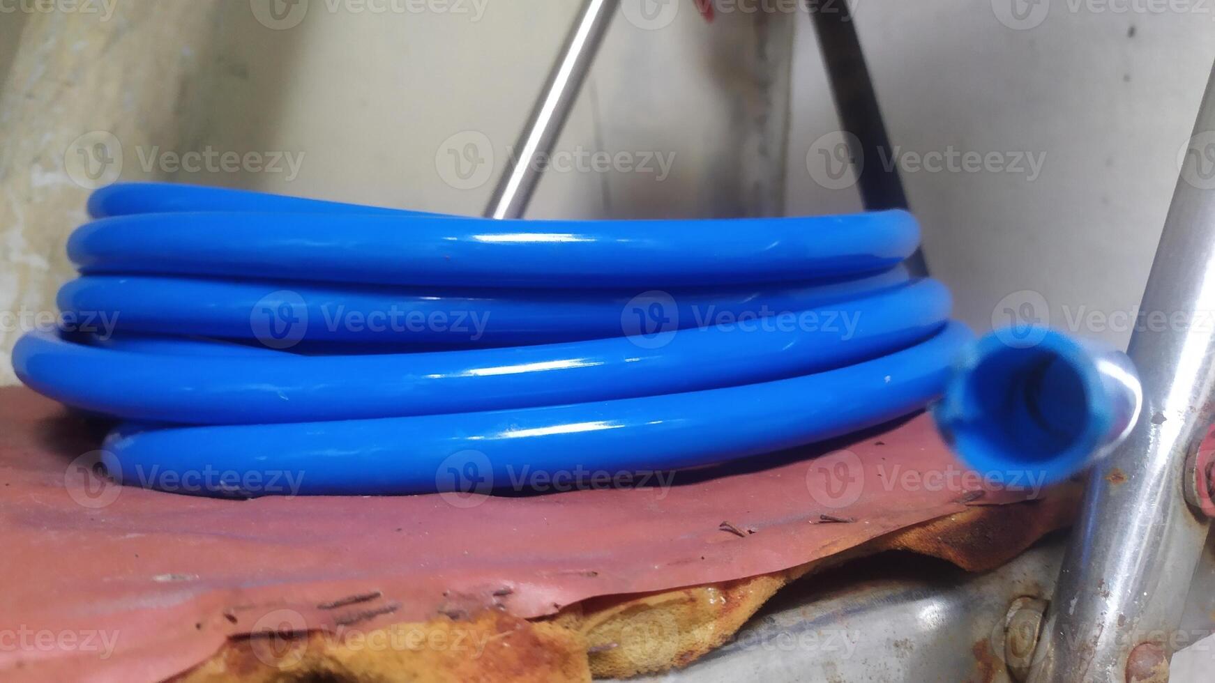 a blue hose with a metal pipe attached to it photo
