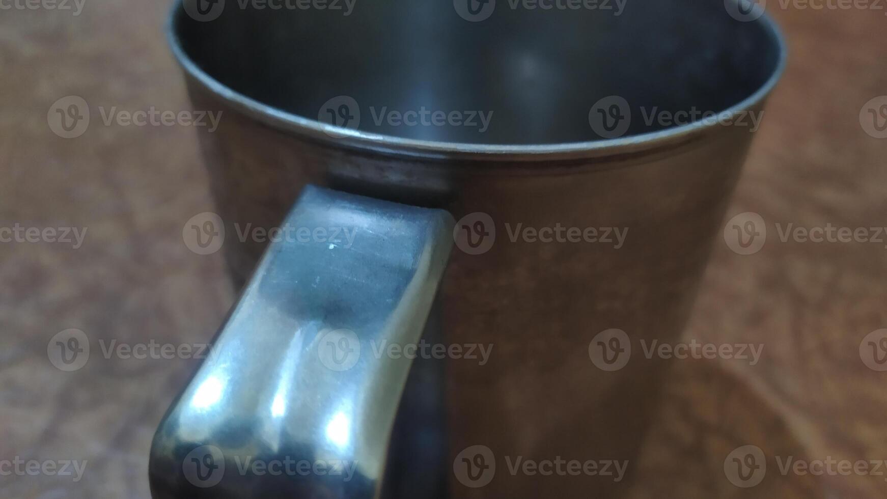 a metal mug with a handle on a table photo