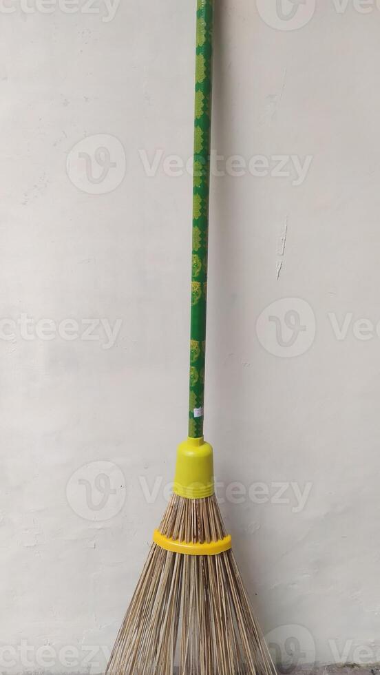 a broom with a yellow handle and green handle, photo