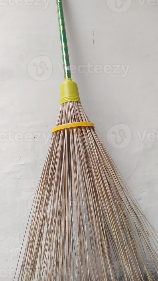 a broom with a yellow handle and a green handle photo