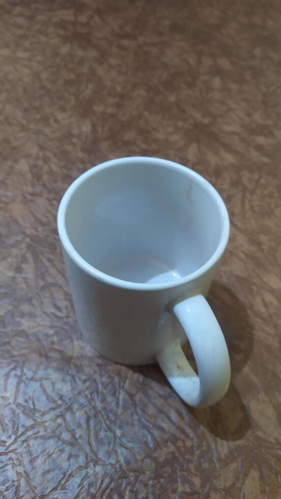 a white coffee cup sitting on a table, portrait photo