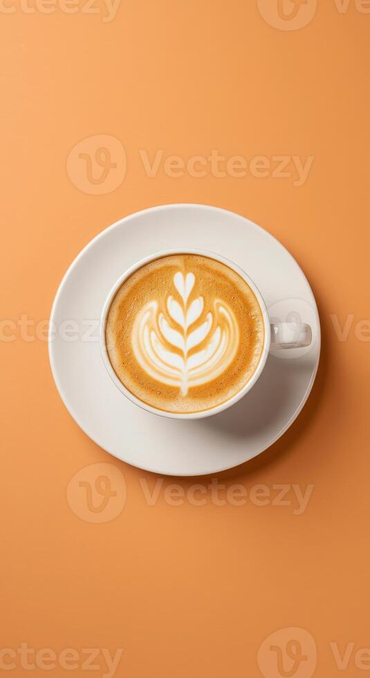 A cup of coffee with a leaf design on top of a saucer photo