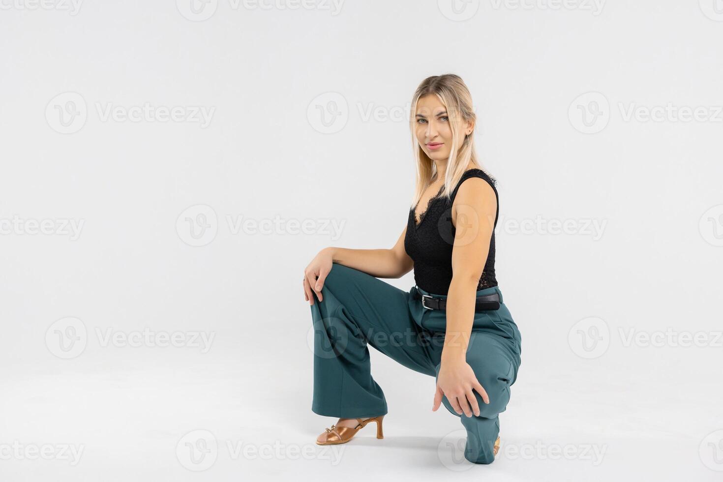 Confident businesswoman crouching in studio, showcasing modern office attire photo