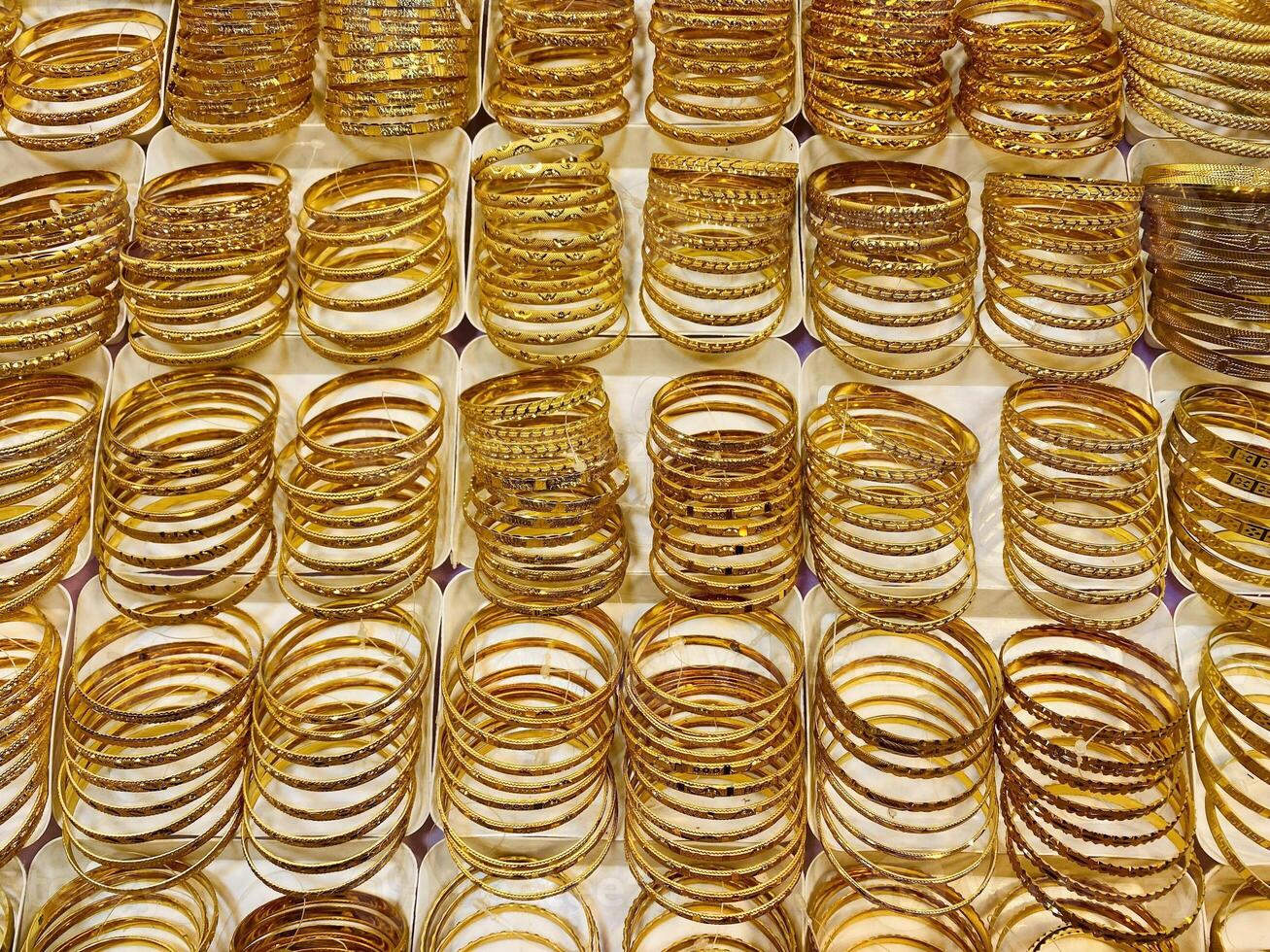 Gold Bracelets. jewelry for sale in market. elegant gold jewelry in the largest market. Rows of gold bracelets in a store. photo