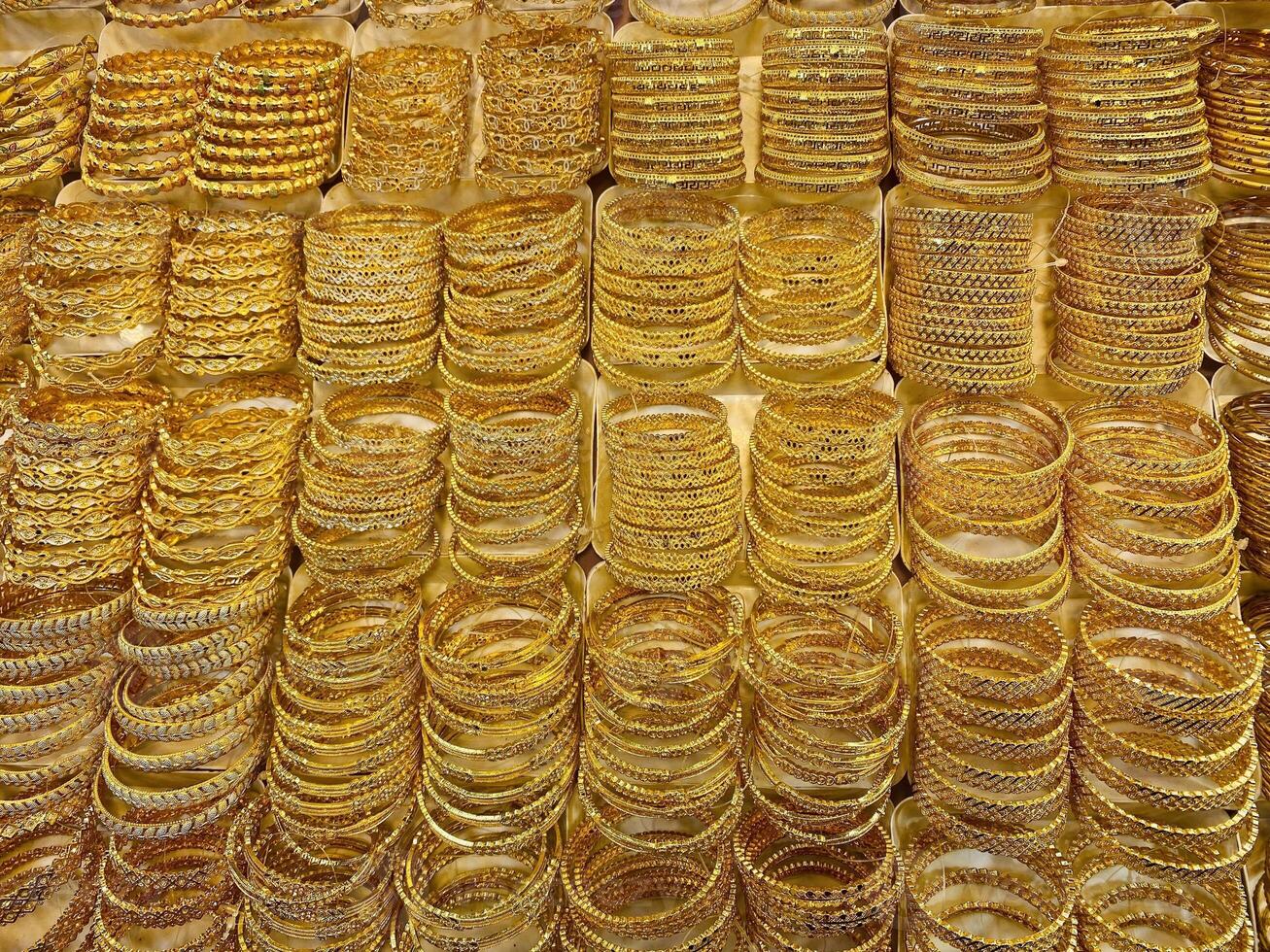 Gold Bracelets. jewelry for sale in market. elegant gold jewelry in the largest market. Rows of gold bracelets in a store. Gold on the famous Golden souk. photo