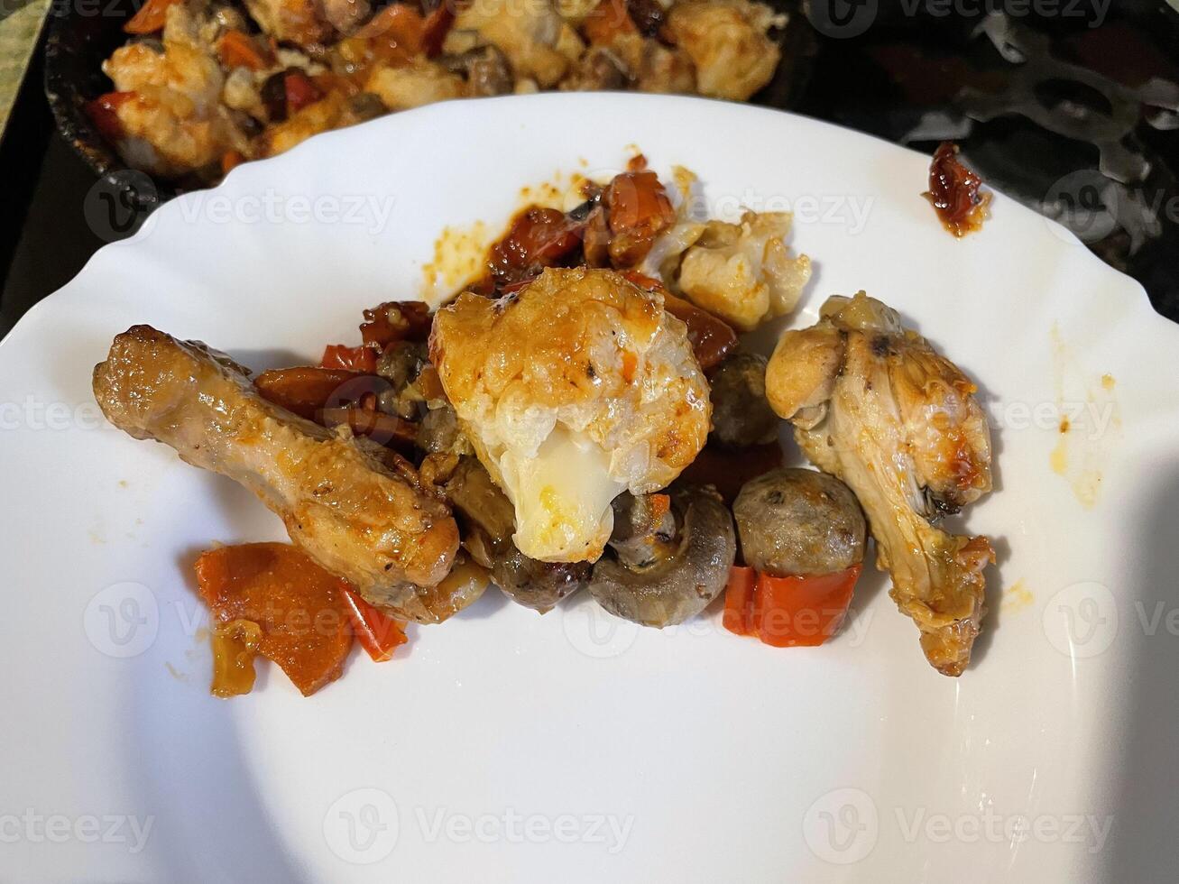 Chicken baked with vegetables in a rustic kitchen setting photo