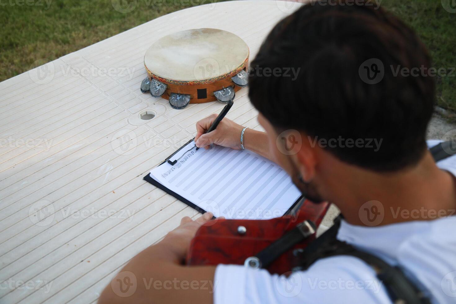 Man Studying Accordion And Watching On The Paper photo