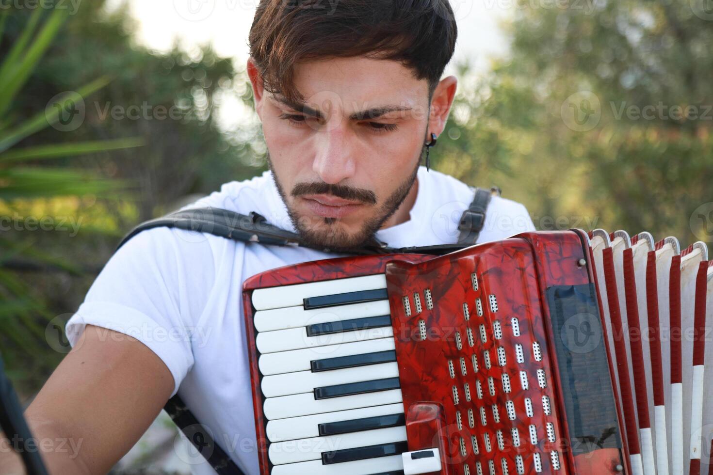Man Studying Accordion And Watching On The Paper photo