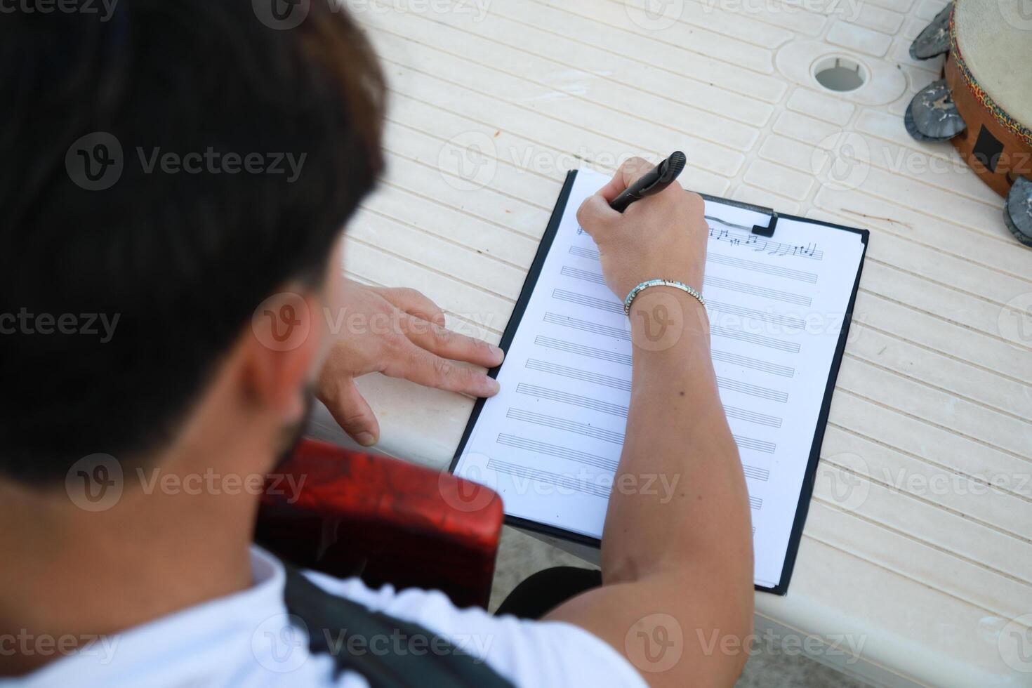 Man Studying Accordion And Watching On The Paper photo