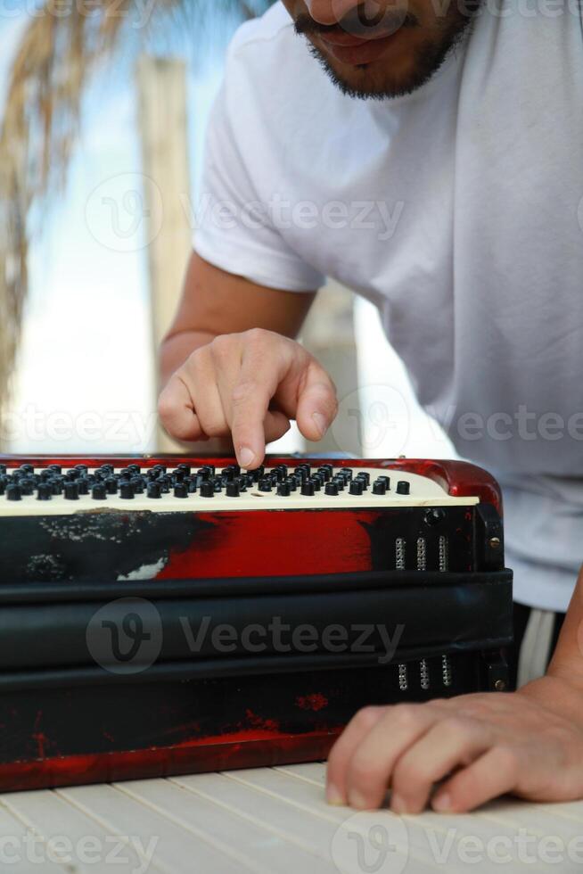 Man Testing All The Buttons Of His Accordion photo
