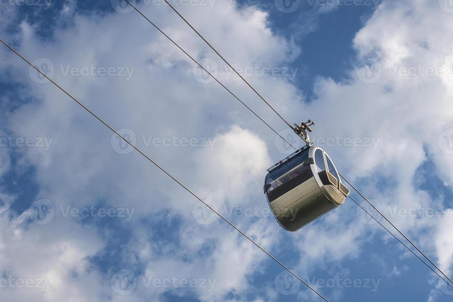 Cable car against blue sky with white clouds. Cable car connects Sparrow Hills well known as Vorobyevy Gory park with Sport Complex Luzhniki. Moscow, Russia. photo