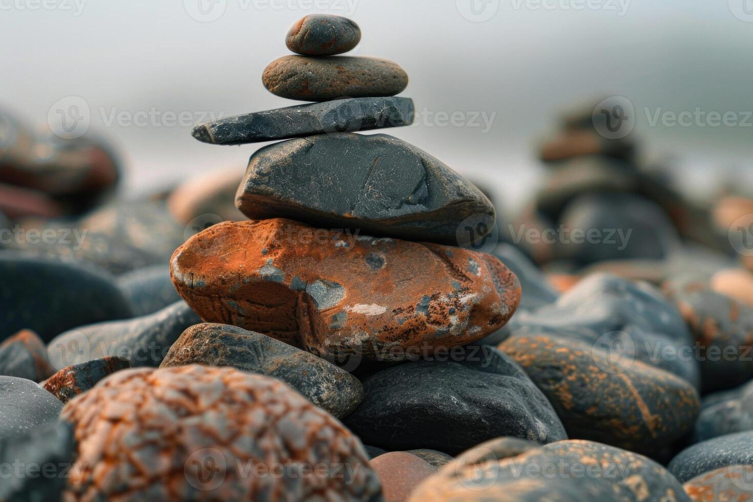 Stack of dark and colorful pebbles balancing on each other on the coast photo