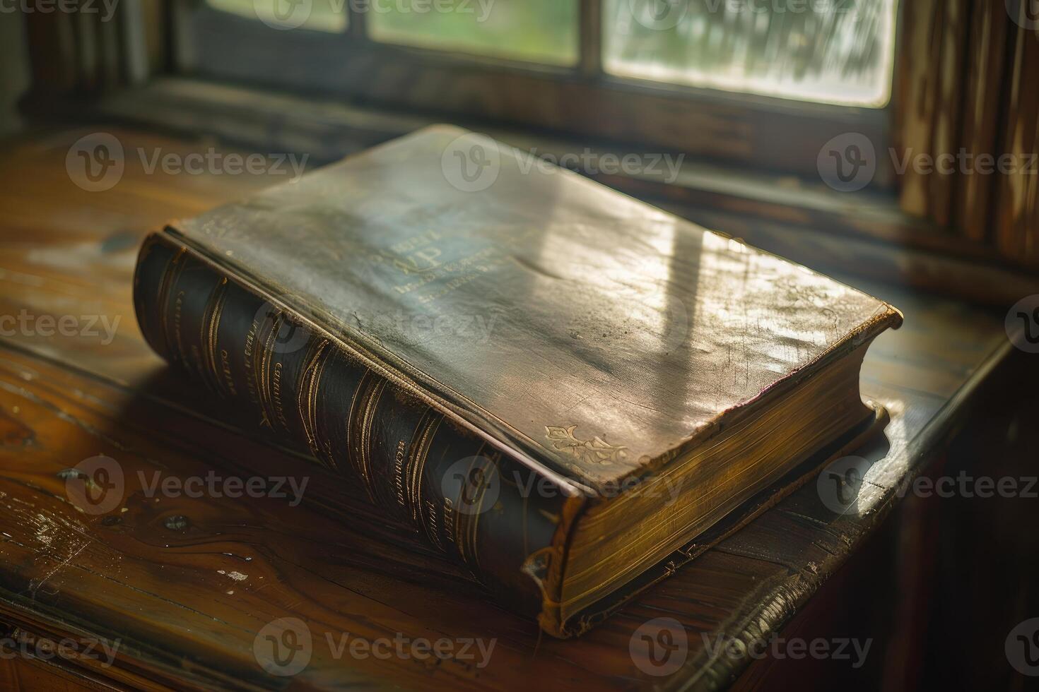 Antique leather bound book resting on desk by window photo
