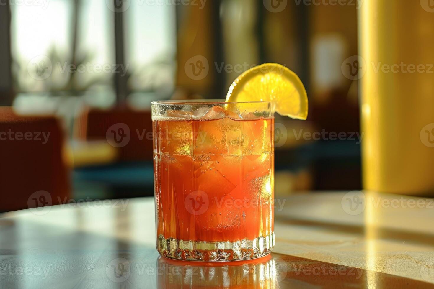 Cocktail with orange and ice cubes is standing on a bar photo