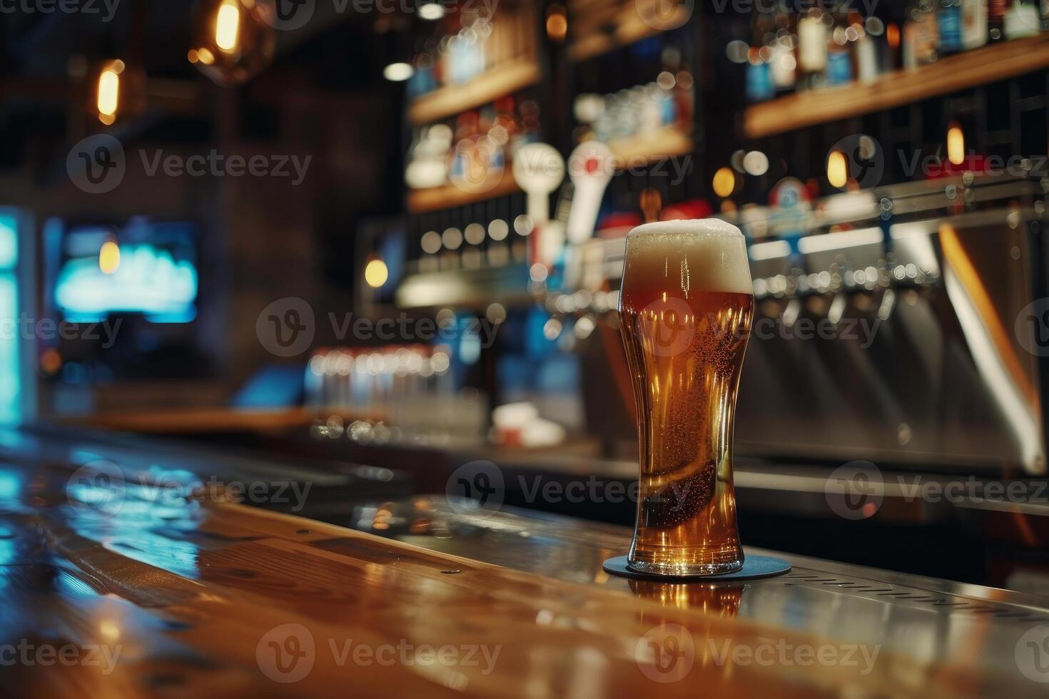 Glass of light beer standing on bar counter in pub photo
