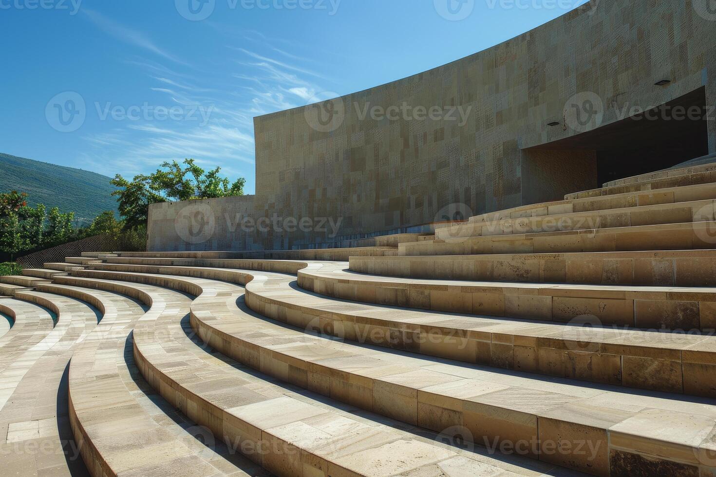 Modern open air amphitheater structure with stone benches on a sunny day photo