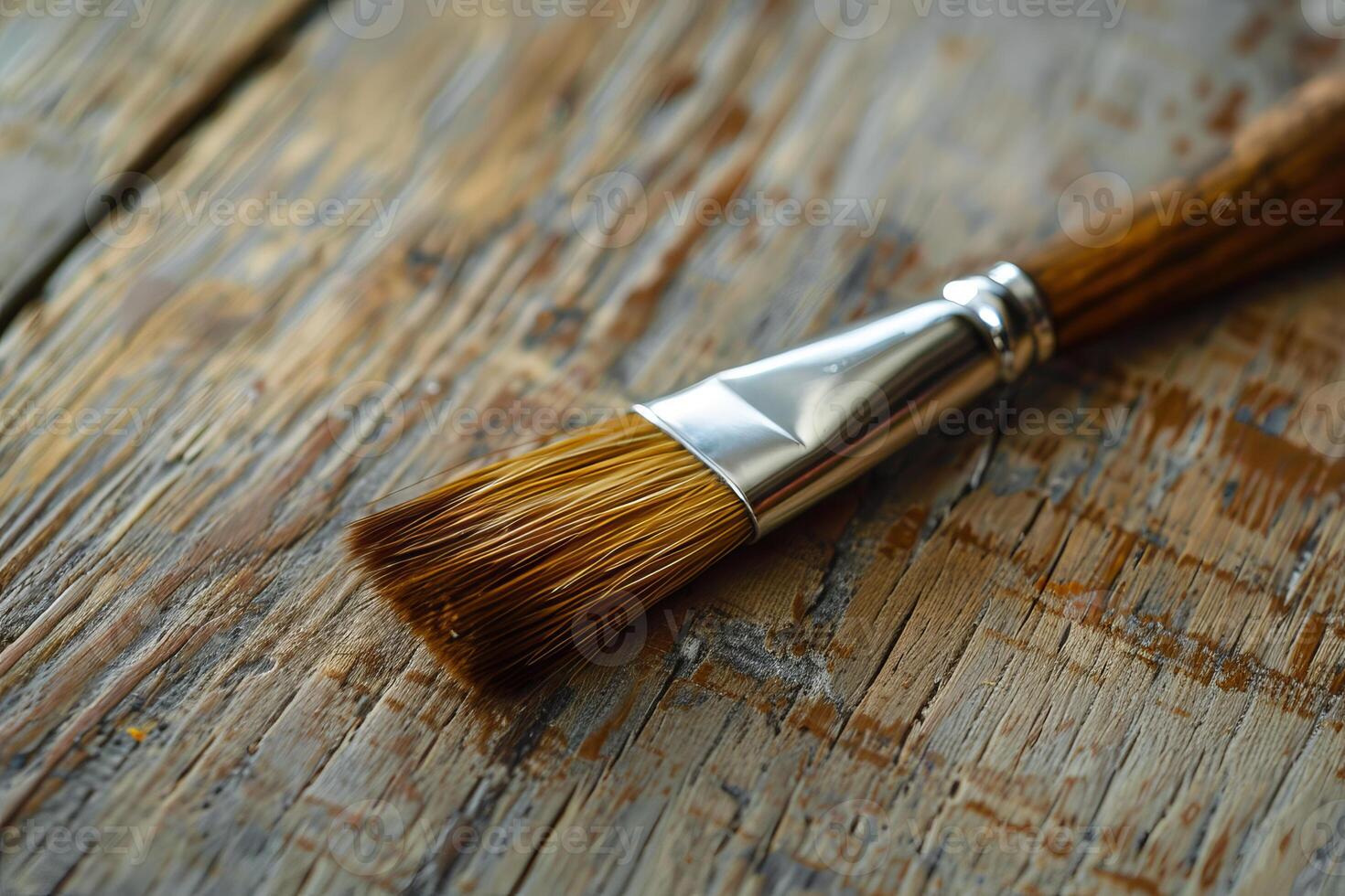 Paint brush resting on a reclaimed wood surface photo