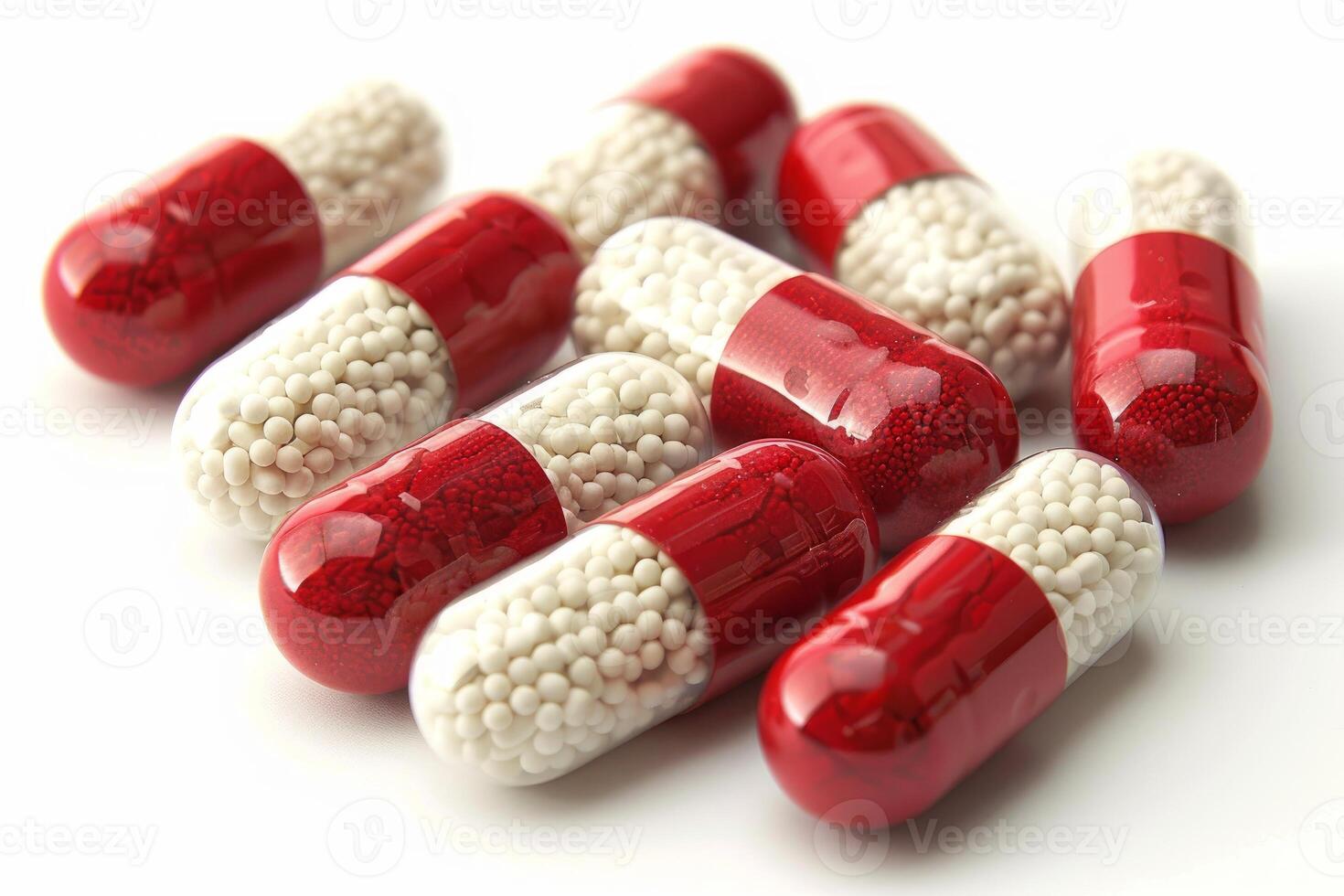 Red and white capsules lying on a white surface photo