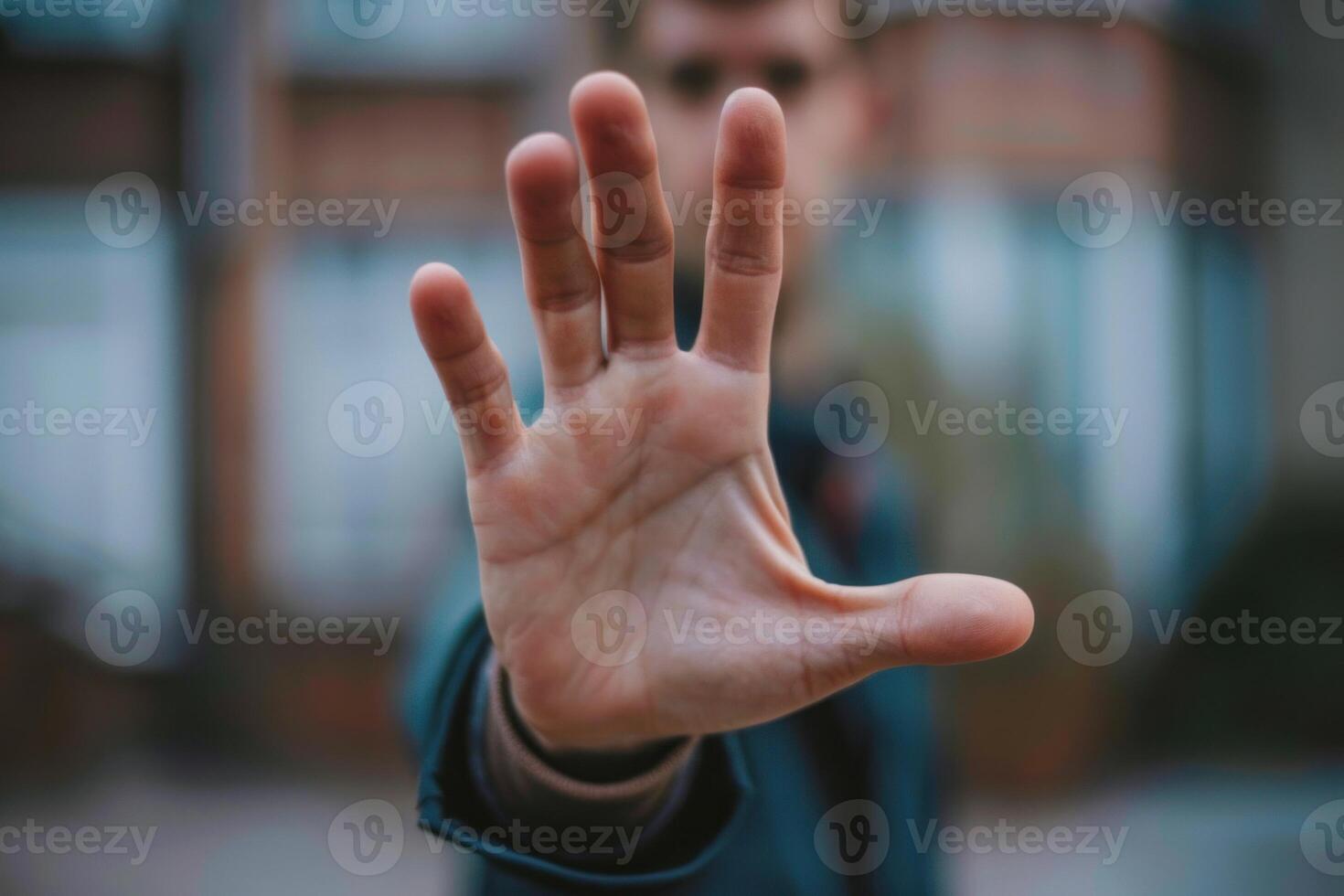 Man making stop sign with hand in front of face photo