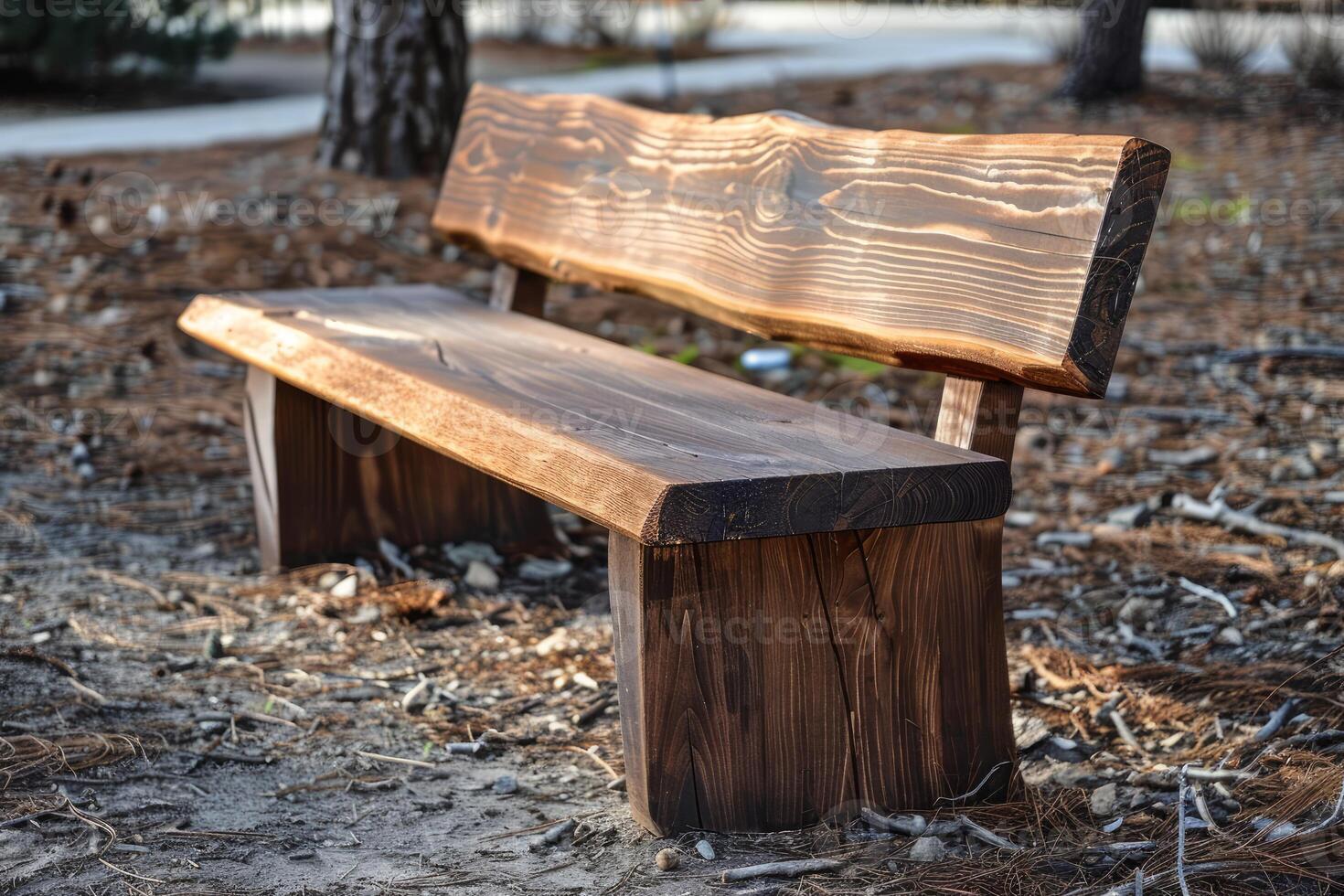 Empty wooden bench standing on dry leaves in a park photo