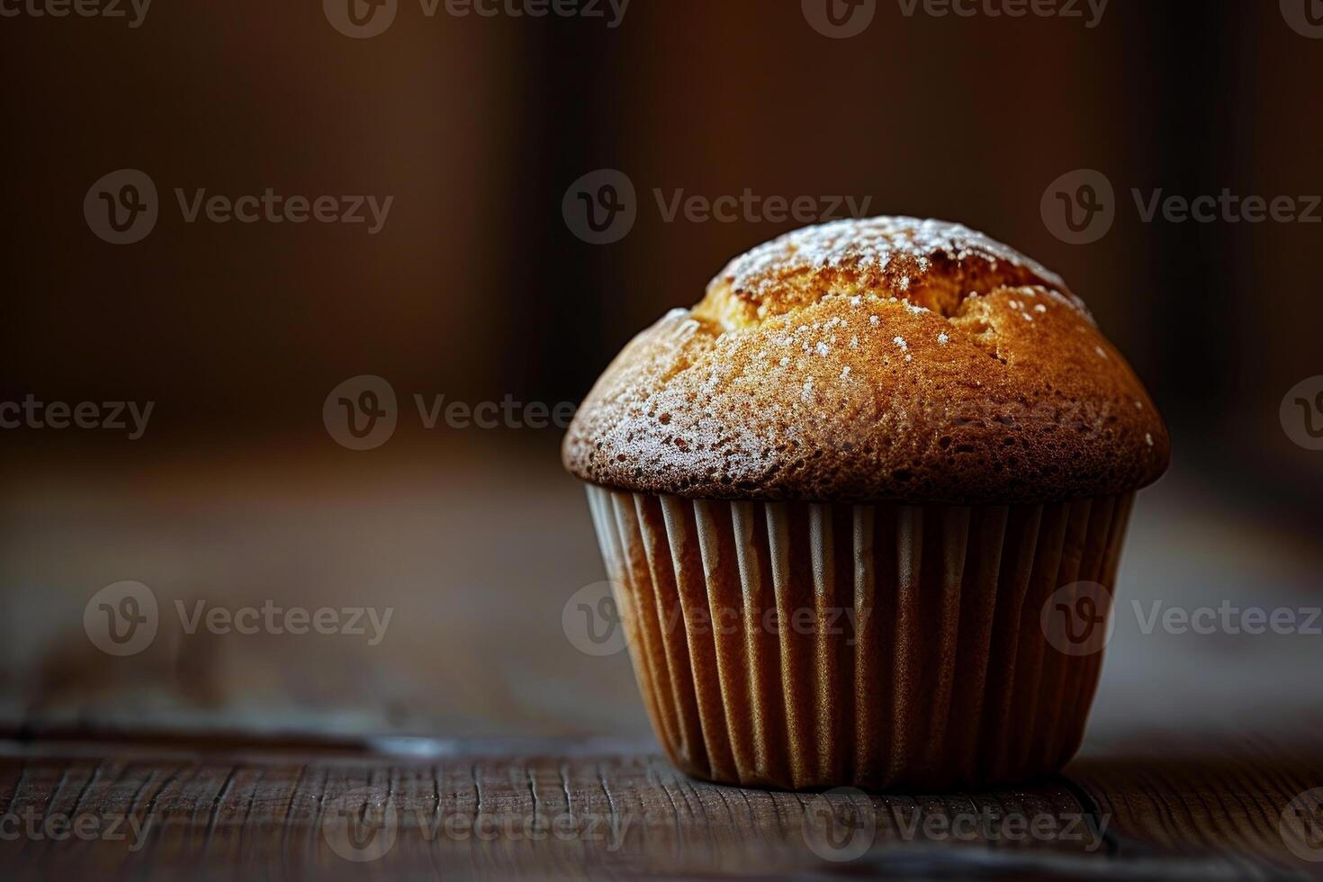 Delicious homemade muffin with powdered sugar sitting on wooden table photo