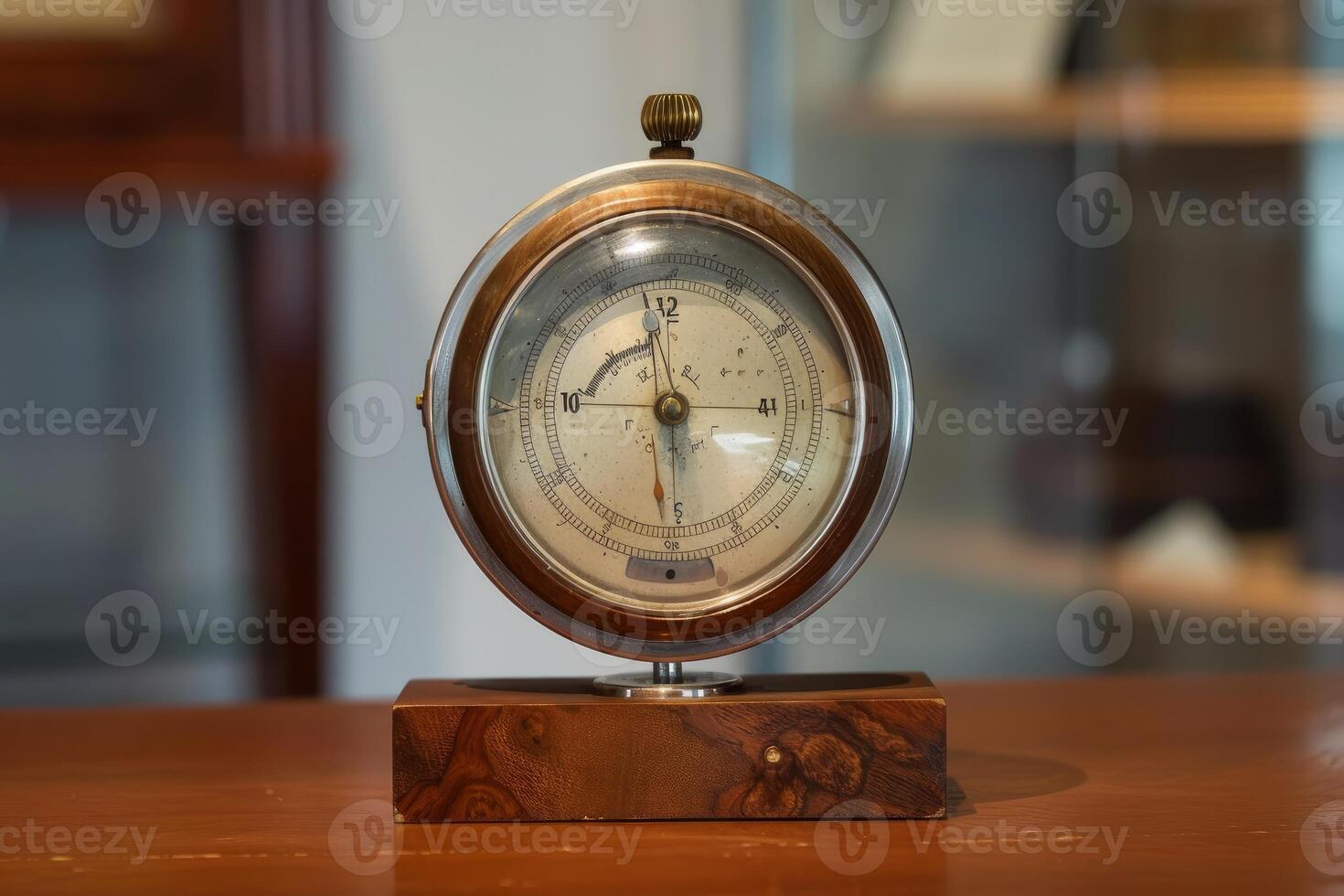 Antique barometer standing on a wooden table is showing air pressure photo