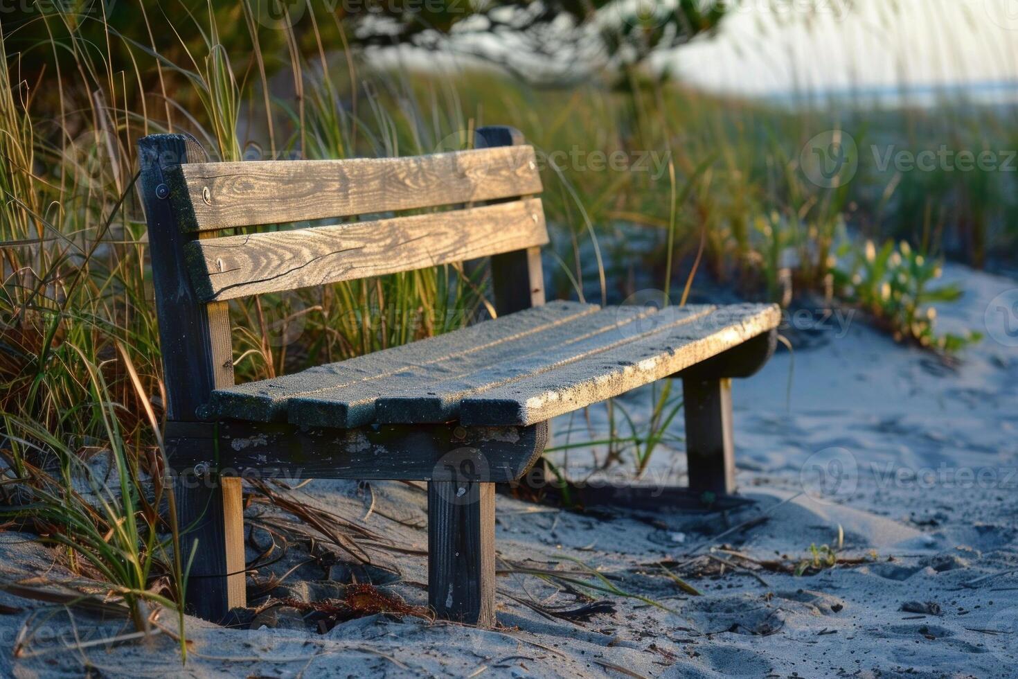 Empty bench resting on sandy beach at sunset photo
