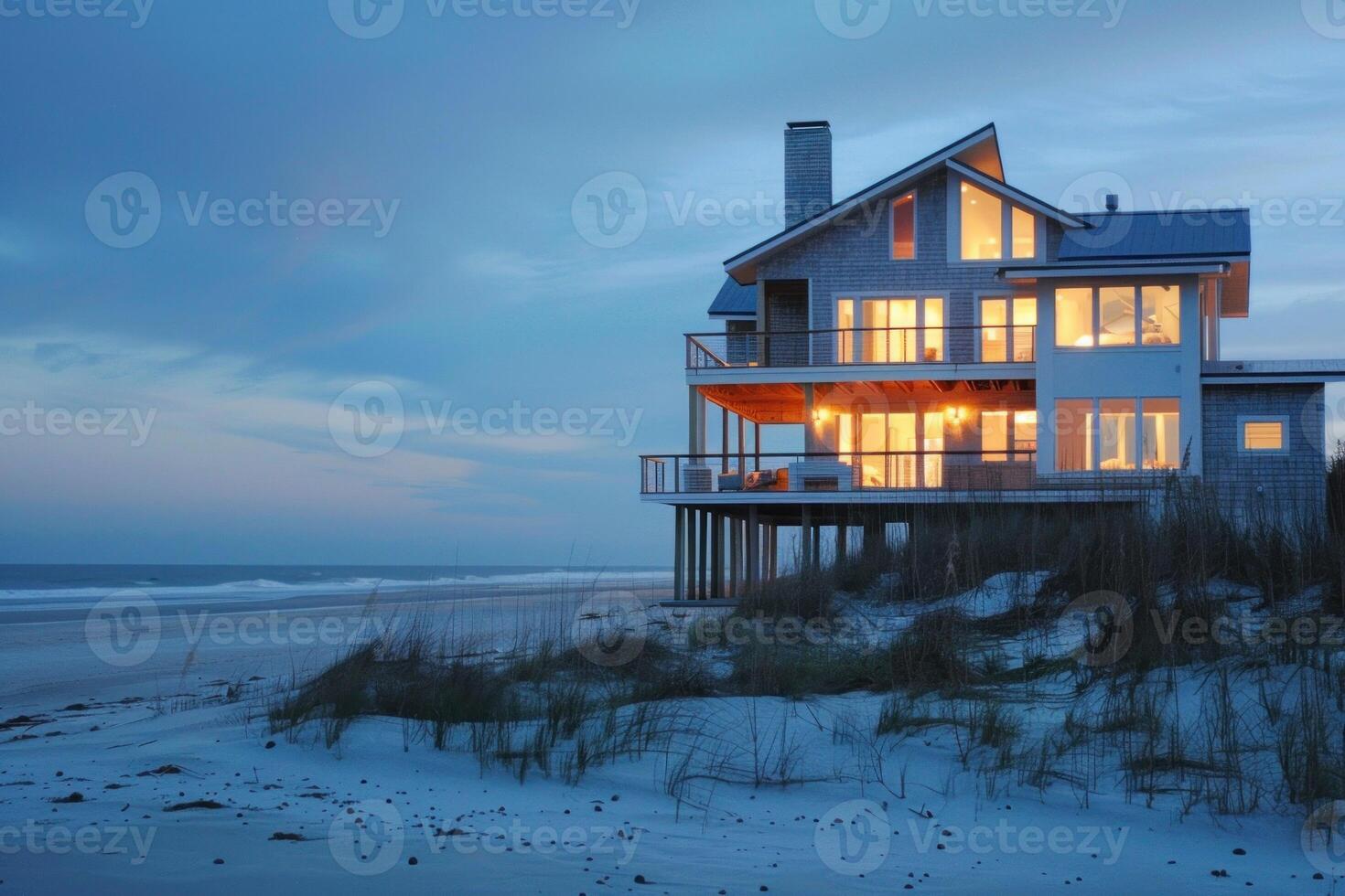 Beach house glowing at twilight on the coast photo