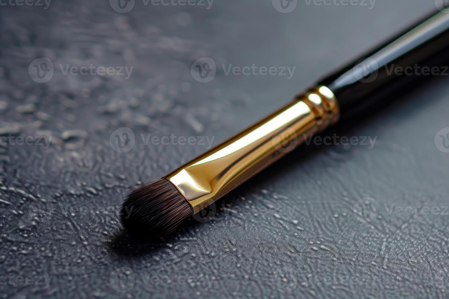 Professional makeup brush lying on dark gray surface photo