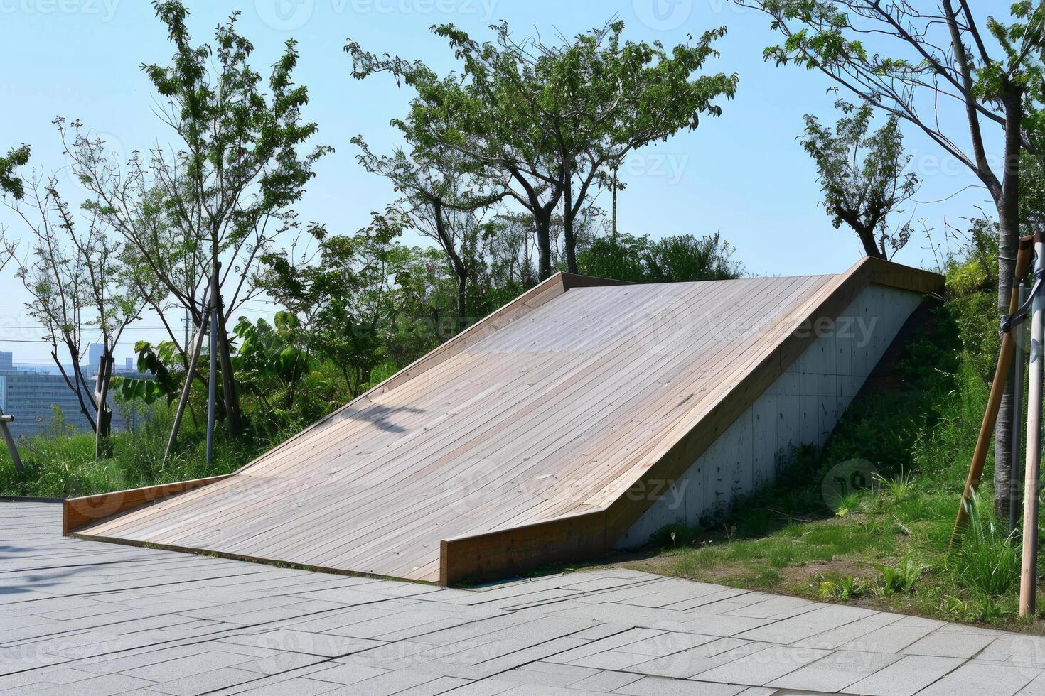 Modern wooden playground slide structure on top of hill with trees photo