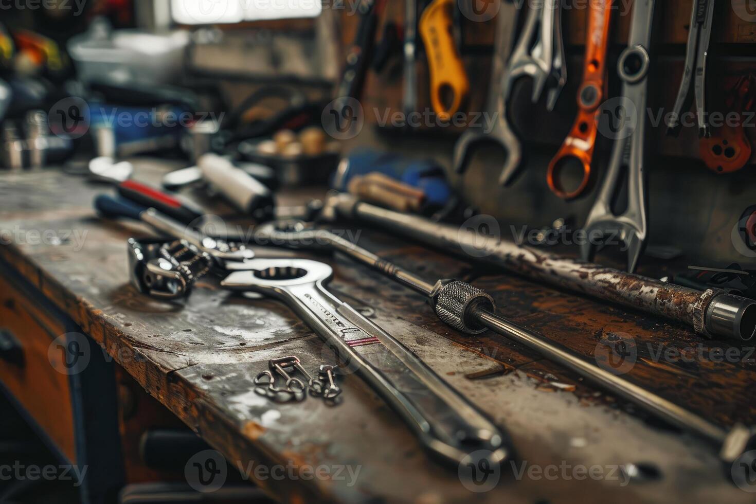 Adjustable wrenches and tools lying on workbench in workshop photo