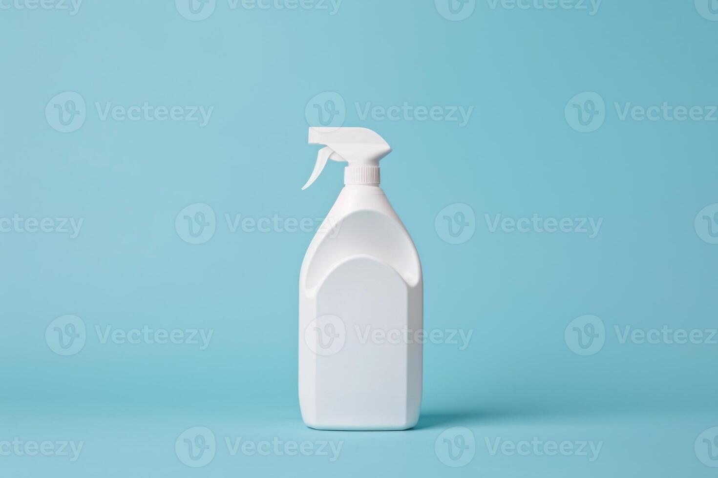 White plastic spray bottle standing on blue background photo