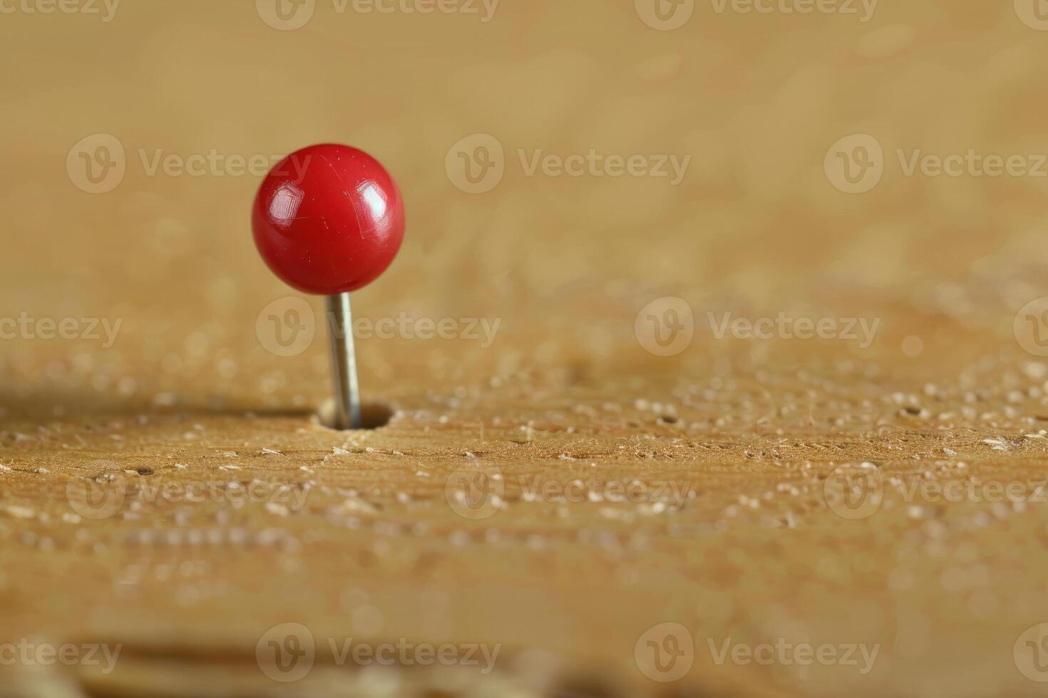 Red push pin standing on wooden surface photo